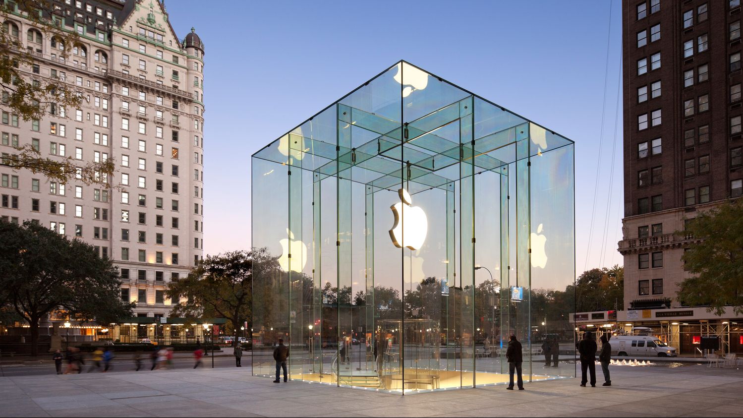 De glazen kubus van Apple Fifth Avenue met het verlichte Apple-logo.