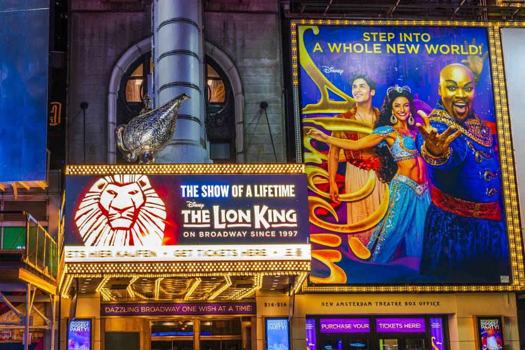 Verlichte Broadway-musicalreclames voor The Lion King en Aladdin.