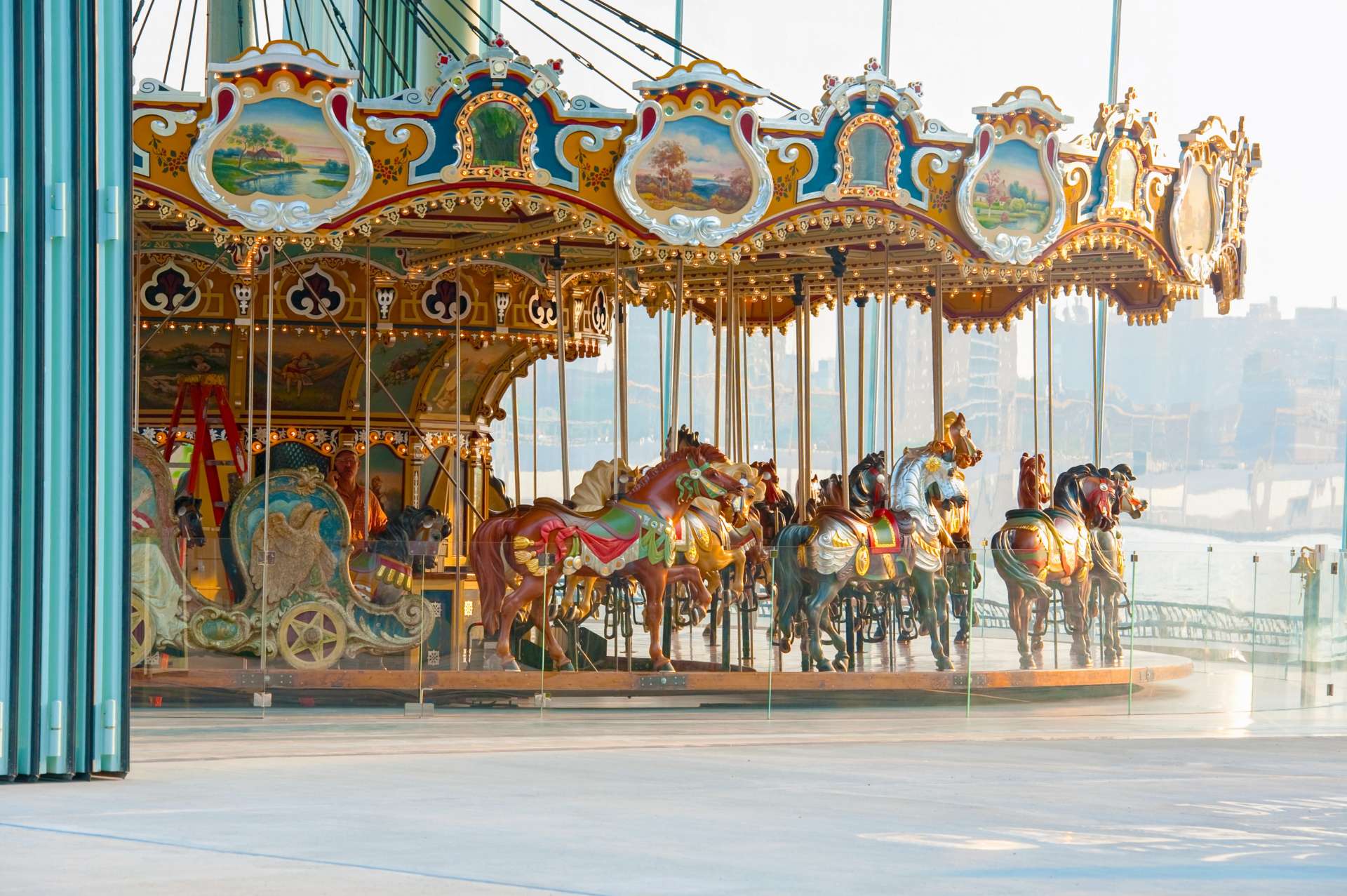 De beschilderde paarden en verlichte ornamenten van Jane's Carousel in het glazen paviljoen.