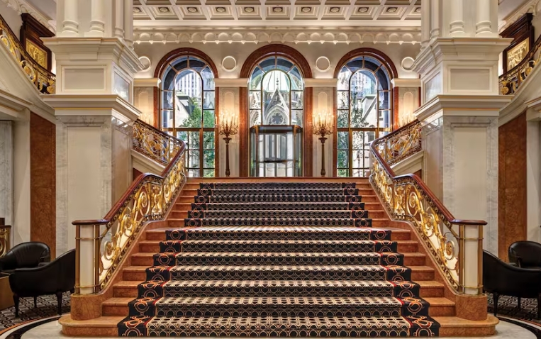 De monumentale trap met sierlijke leuningen in Lotte New York Palace.