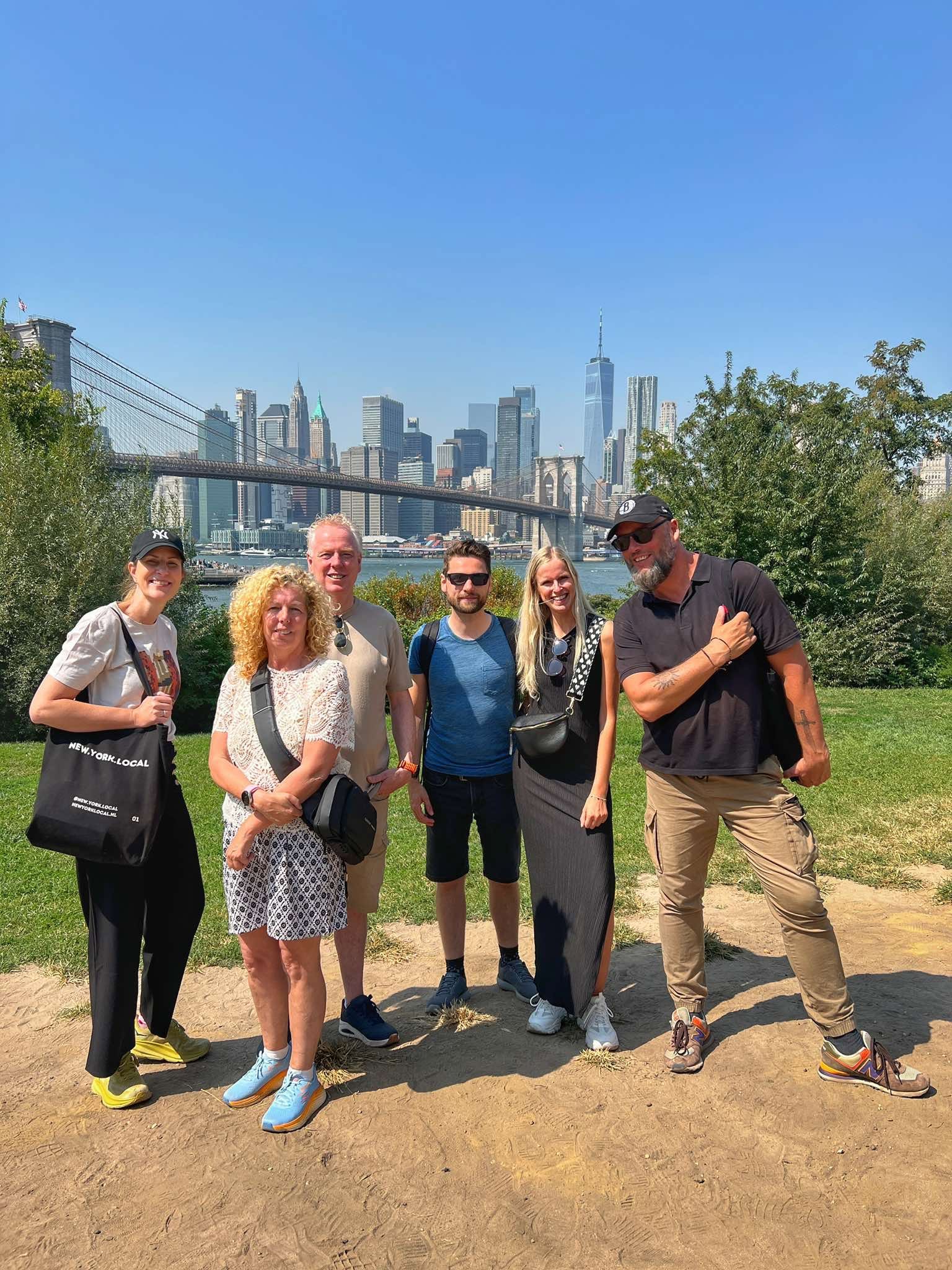 Een groep tijdens de Brooklyn-wandeltour van New.York.Local met de Brooklyn Bridge en skyline van Manhattan op de achtergrond.