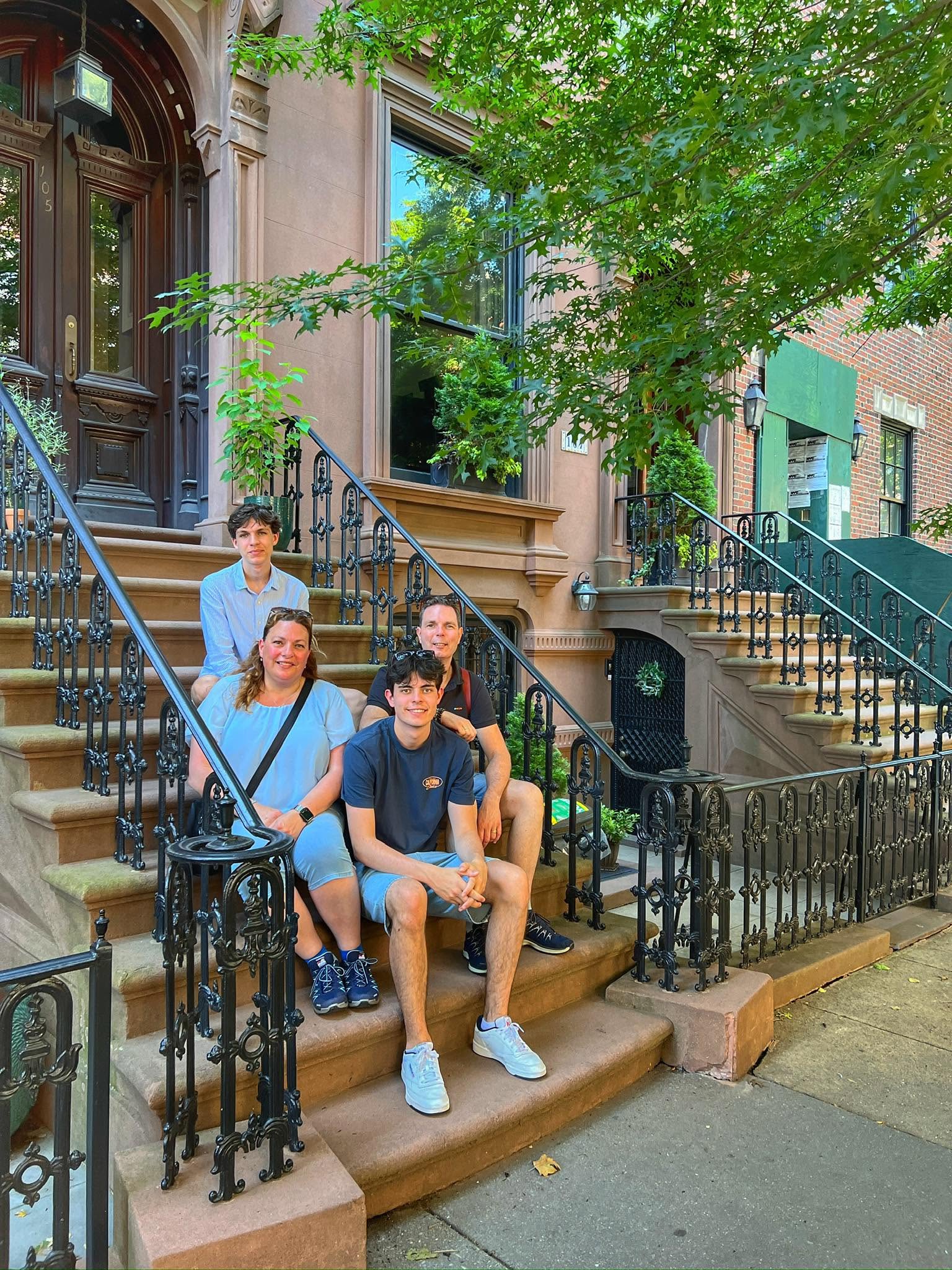 Een groep tijdens de SoHo en The Village Tour van New.York.Local, zittend op de trappen van een brownstone.