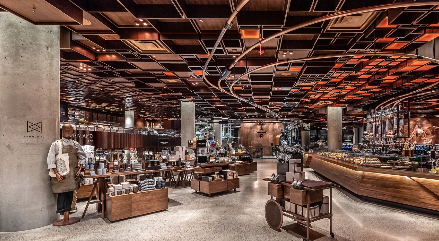 Het interieur van Starbucks Reserve Roastery met koperen plafond, koffiebalie en winkelgedeelte.