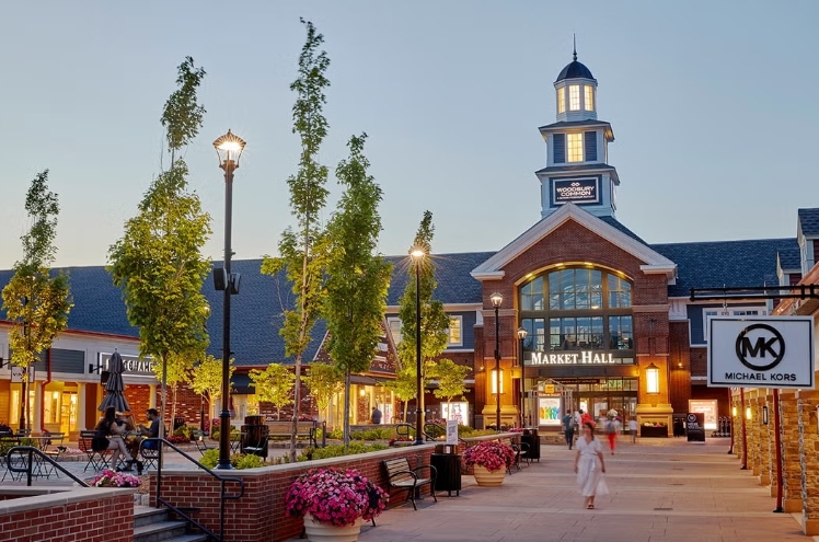 De verlichte Market Hall en winkels van Woodbury Common Premium Outlets.